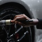 A Person Cleaning Tire of a Car